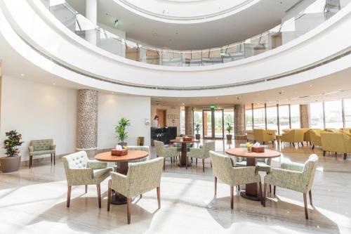 a lobby with tables and chairs and a domed ceiling at Aram Hotel - AlMeshael Exit 18 in Riyadh