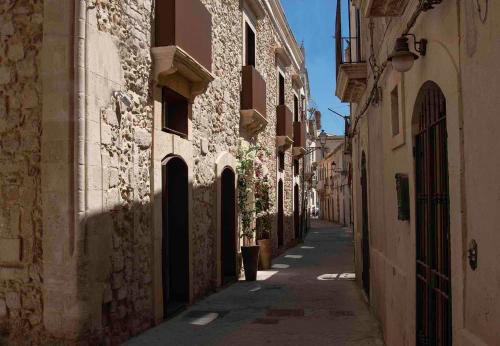 a narrow alley with buildings in an old town at Palazzo Salomone in Siracusa