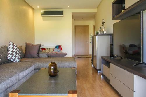 a living room with a couch and a refrigerator at Modern Lakeview Apartment With Private Garden in Marrakesh