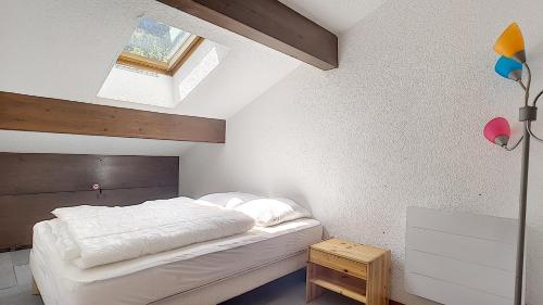a small bedroom with a bed and a skylight at Cimes 68 - ST JEAN D'AULPS - PIED DES PISTES - PROCHE MORZINE in Saint-Jean-d'Aulps
