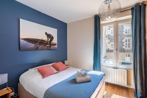 een slaapkamer met een bed en een groot raam bij Le Traou Mad - Au cœur de l'Intra-muros in Saint-Malo