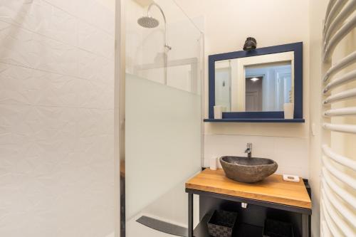 een badkamer met een wastafel en een spiegel bij Le Traou Mad - Au cœur de l'Intra-muros in Saint-Malo