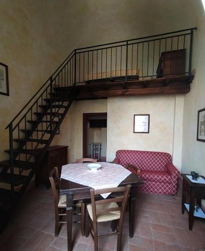 a living room with a table and a staircase at Monastero Le Grazie in Amelia