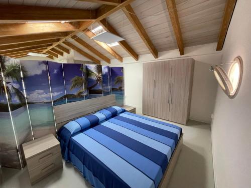 a bedroom with a blue bed in a room at Loft Regina Margherita in SantʼAntìoco