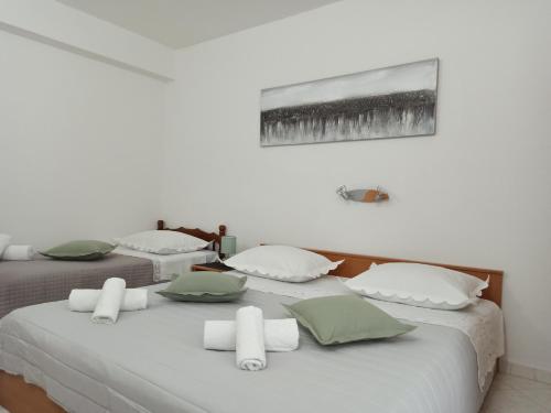 two beds with green and white pillows on them at Olivera in Promajna