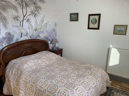 1 dormitorio con 1 cama con un patrón en la pared en La Visitation - 30, en Orthez