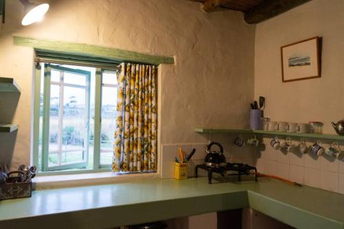 eine Küche mit einem Fenster und einer Arbeitsplatte in der Unterkunft Paddahoek Cottage in Vermaaklikheid