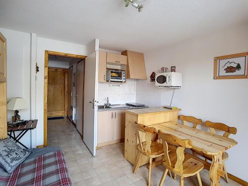 une petite cuisine avec une table et des chaises en bois dans l'établissement Ourson 14, à Saint-Jean-dʼAulps