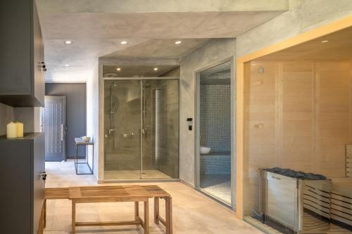 y baño con ducha de cristal y mesa. en Malvezzino Luxury Villas en Palaiokastro