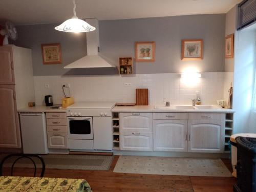 une cuisine avec des appareils blancs et un évier dans l'établissement Les Cazelles, à Conques-en-Rouergue