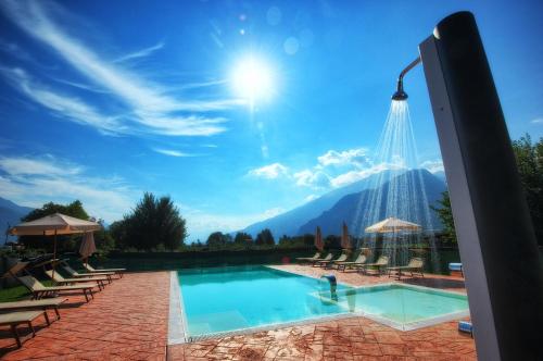 a swimming pool with a mountain in the background at Agriturismo alla Poncia in Gravedona