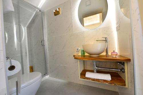 a bathroom with a sink and a toilet and a mirror at “A Casa” luxury in Francavilla Fontana