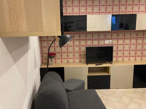 a living room with a couch and a television at Maratea apartment in Maratea