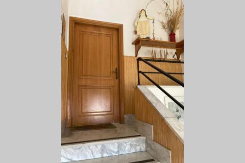 un couloir avec une porte en bois et quelques escaliers dans l'établissement Appartamento nelle Terre del Tufo, à Sorano