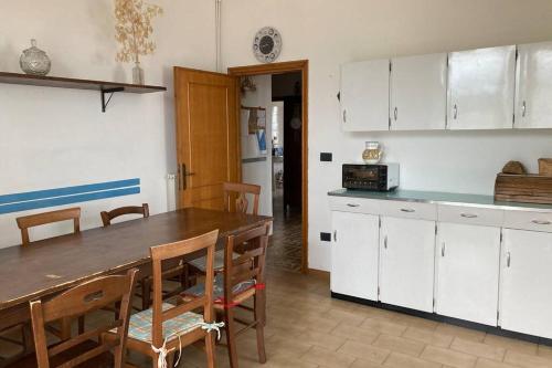 - une cuisine avec une table en bois et des placards blancs dans l'établissement Appartamento nelle Terre del Tufo, à Sorano