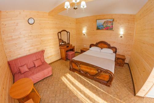 a bedroom with a bed and a couch in a room at Hotel Anapskiy Briz in Anapa