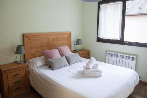 a bedroom with a large white bed with towels on it at Apartamento Toran in Les