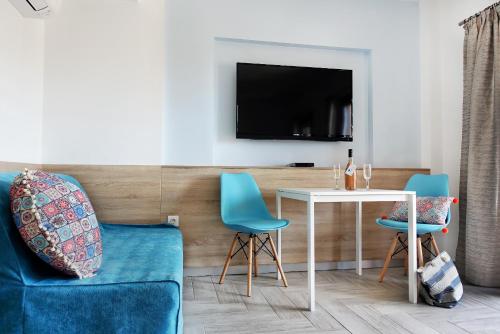 ein Wohnzimmer mit einem Tisch und Stühlen sowie einem TV in der Unterkunft Okean Studios in Ierissós