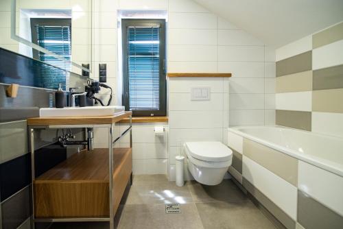 a bathroom with a toilet and a sink and a tub at 12 Jabłek - ośrodek wypoczynkowy na Mazurach in Nidzica