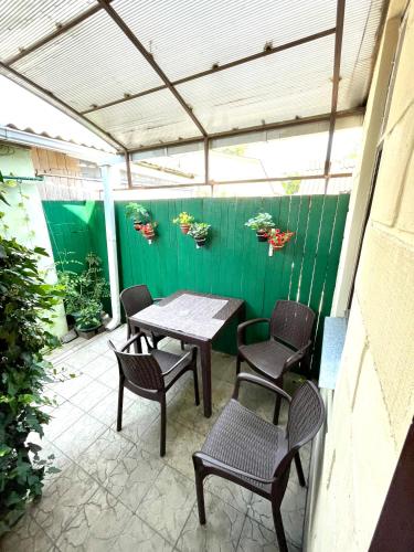 エイスクにあるУ ЗоИ на Мираの緑の壁のパティオ(テーブル、椅子付)