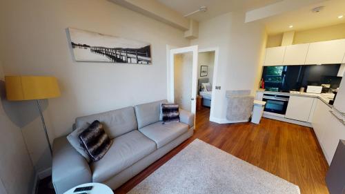 a living room with a couch and a kitchen at The Westfield in Edinburgh