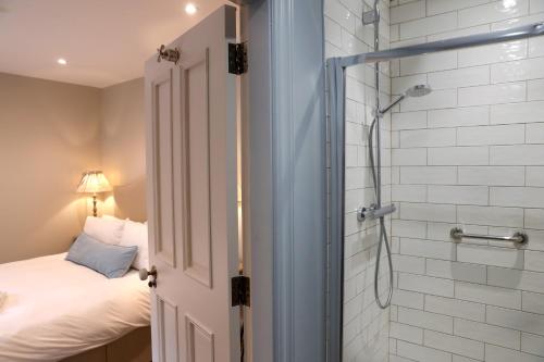 a bathroom with a shower and a bed in a room at Old Post Office in Slane