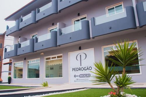 a building with a balcony on top of it at Pedrógão Guesthouse in Pedrógão