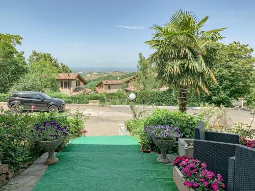 a green carpeted driveway with a palm tree and flowers at La LocAnna in Serramazzoni