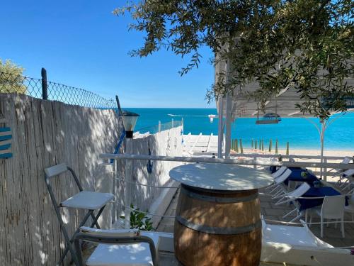 einen Tisch und Stühle mit dem Strand im Hintergrund in der Unterkunft B&B direttamente sul mare da Antonino in Mattinata