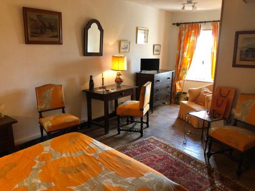 a bedroom with a bed and a desk and chairs at Le Gite du Pavillon - Sainte-Croix-du-Mont in Sainte-Croix-du-Mont