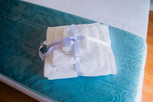 a pair of towels with a purple ribbon on a couch at Pedrógão Guesthouse in Pedrógão