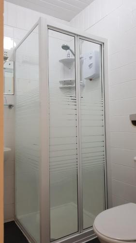 a bathroom with a glass shower with a toilet at Malvern Hotel in Sandown