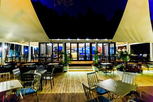 un ristorante con tavoli e sedie di notte di ECUADOR Resort a Zverneci