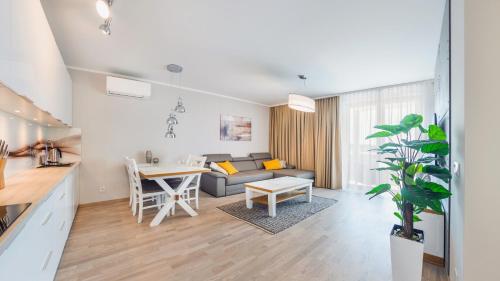 a kitchen and living room with a couch and a table at Rezydencja Park, Sun & Snow in Mielno