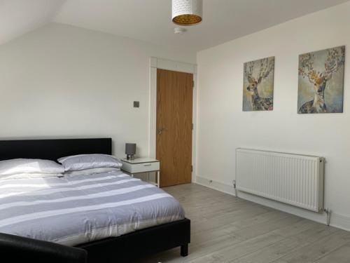 a bedroom with a bed and a wooden floor at 14 Millstone Court in Portstewart