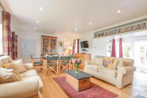 uma sala de estar com dois sofás e uma mesa em Easdale Cottage em Oban