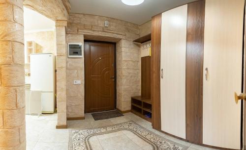 un couloir avec une porte marron et un tapis dans l'établissement Новые апартаменты на Зарванской., à Kamianets-Podilsky
