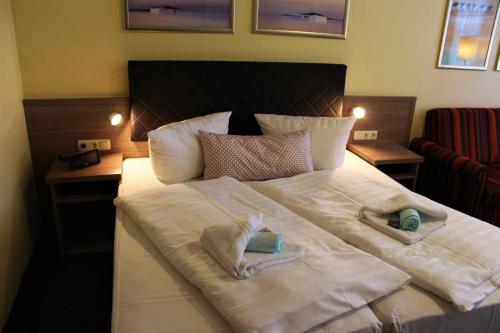 a large white bed with two towels on it at Gasthof Zur guten Quelle in Schwerin