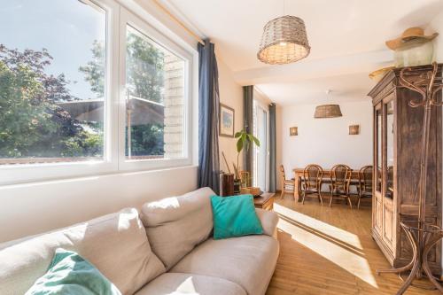 un salon avec un canapé et une fenêtre dans l'établissement La Maison Bleue au coeur des Plages du Débarquement, à Ver-sur-Mer
