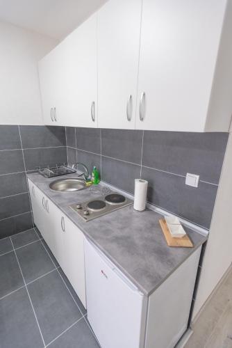 a kitchen with white cabinets and a sink at Apartmani Centar Loznica in Loznica