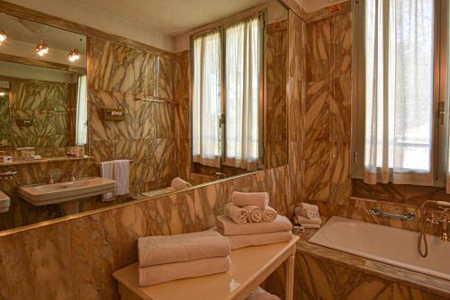 ein großes Bad mit einer Badewanne und einem Waschbecken in der Unterkunft Grand Hotel De Londres in Sanremo
