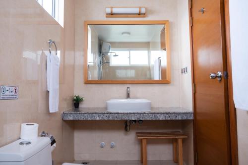 a bathroom with a sink and a mirror at Reef Edge Thulusdhoo, Maldives in Thulusdhoo