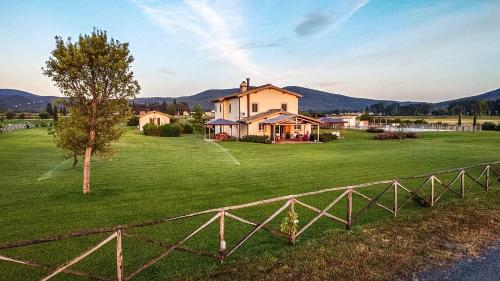 a house on a green field with a fence at Casa Terzerie in Braccagni