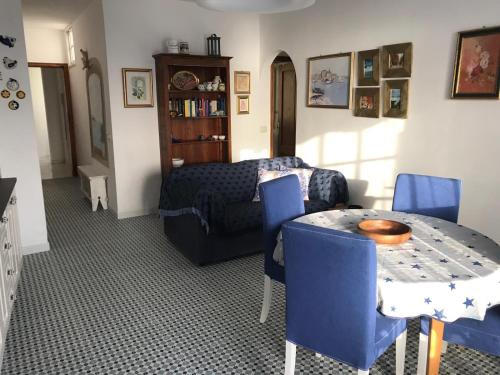 salon ze stołem i niebieskimi krzesłami w obiekcie Casa Massimo w mieście Playa de San Juan