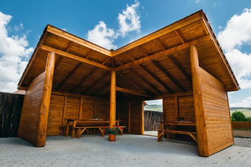 a large wooden pavilion with two tables in it at Vendégváró Panzió in Lupeni