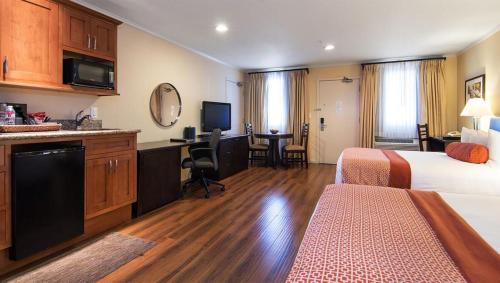 a hotel room with a bed and a desk and a kitchen at The Zen Hotel Palo Alto in Palo Alto