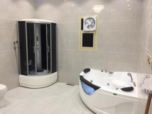 een badkamer met een ligbad en een toilet bij شقق نيام بارك للشقق المخدومه in Rafha