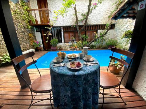 a table with a blue table cloth on a patio at Pousada Arte Urquijo in Paraty