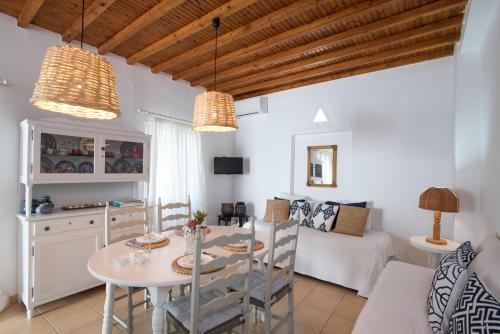 een keuken en een woonkamer met een tafel en stoelen bij Charming House Platy Gialos in Platis Yialos Mykonos