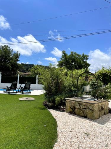 einen Garten mit einem Brunnen inmitten eines Gartens in der Unterkunft A Casa de Pia in Sober